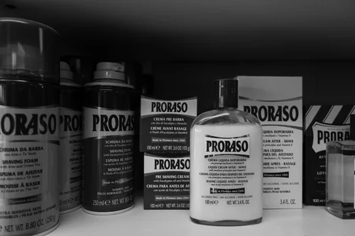 A row of Proraso shaving creams on the shelf.