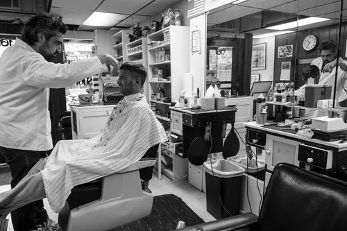 A wide view of the shop interior with a barber chair in the foreground.