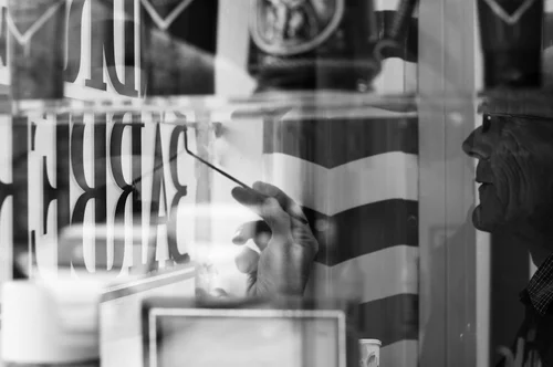 The sign painter visible through the front window, working on the lettering.
